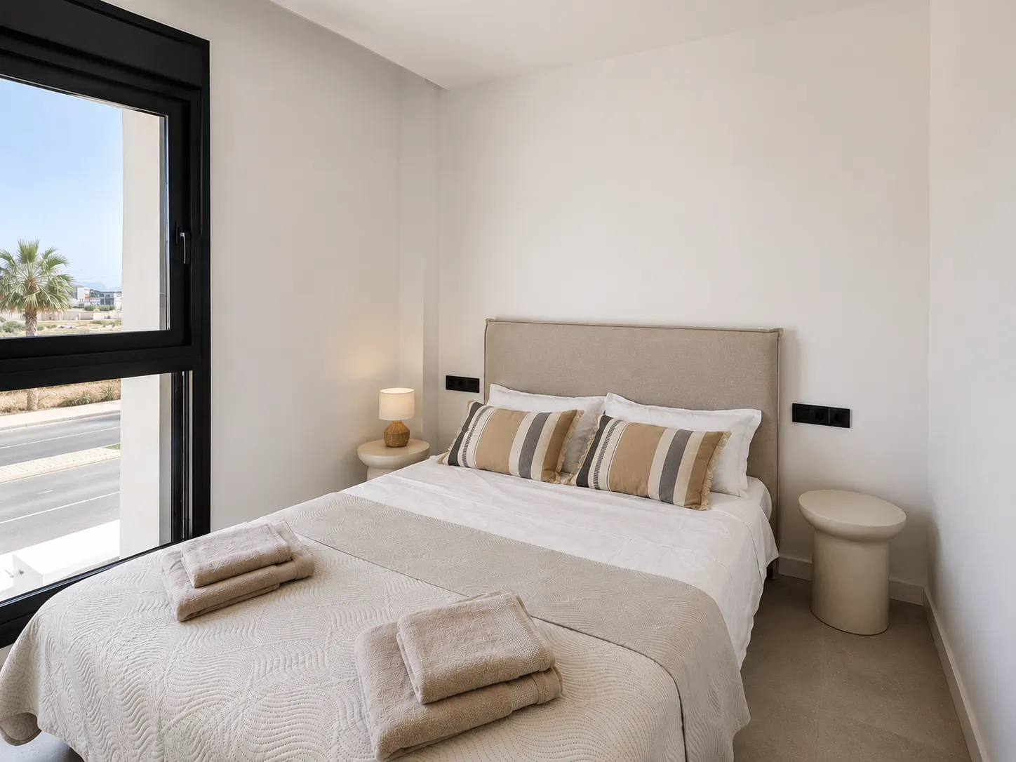 Bedroom with a double bed, fresh towels for guests and a large window